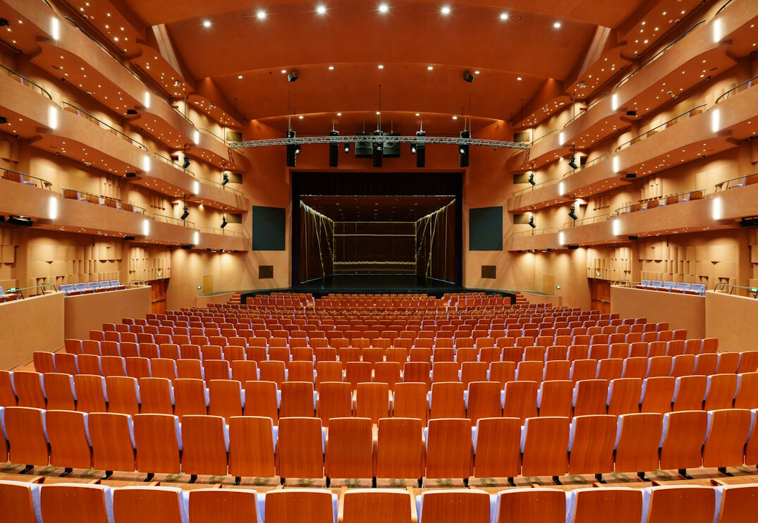 Empty theater hall with rows of seats facing a stage